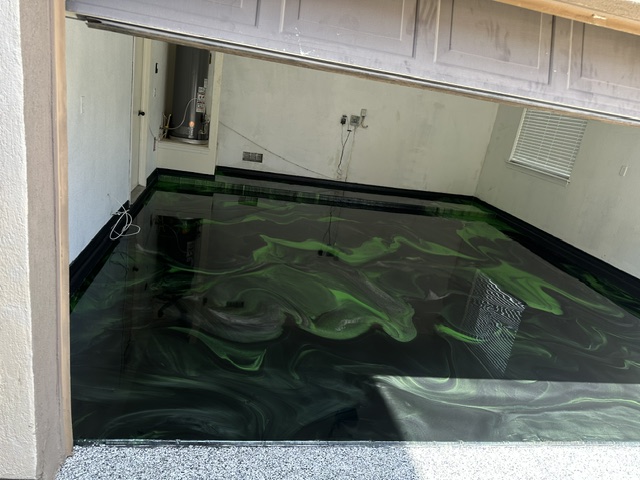 Dark green and black metallic swirl epoxy floor in a residential utility space