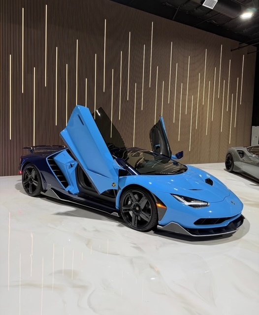 Blue Lamborghini Centenario in a private showroom on a polished white epoxy floor